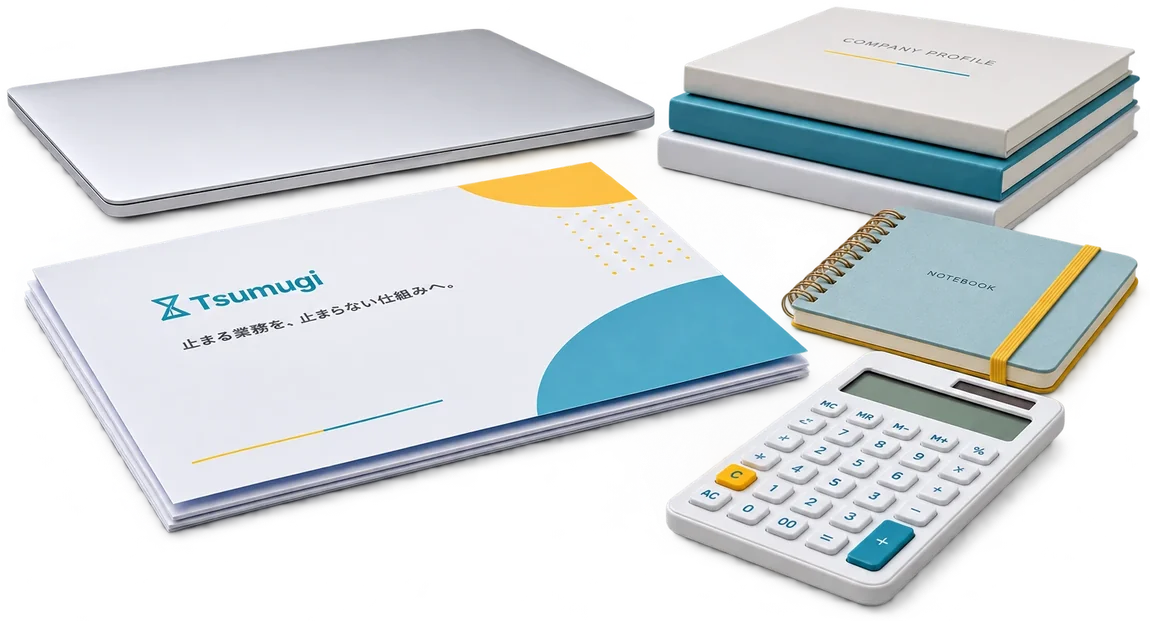 ノートパソコンやTsumugiの会社案内、COMPANY PROFILEの冊子が並ぶデスク